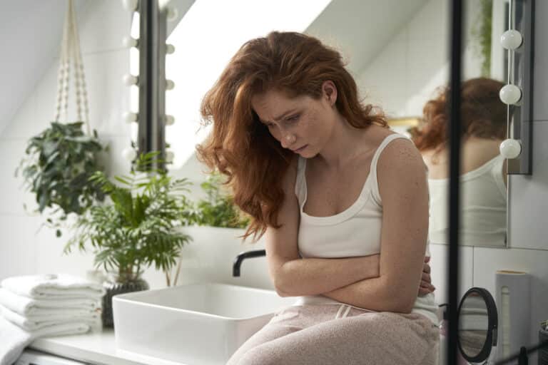 Frau mit Übelkeit als Symbol für Emetophobie und Angst vor Erbrechen