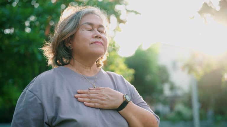 Frau beruhigt den Vagusnerv mit ruhiger Atmung